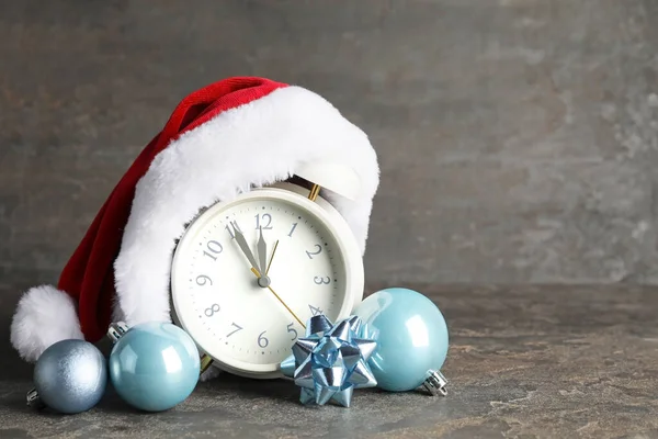 Weihnachtsmütze Mit Wecker Und Weihnachtsdekor Auf Dunklem Hintergrund — Stockfoto