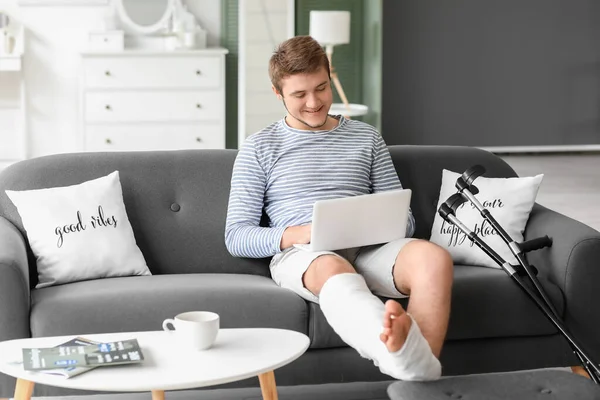 Jovem Com Perna Quebrada Usando Laptop Casa — Fotografia de Stock