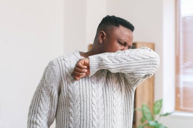 Öksüren Afro-Amerikalı adam.