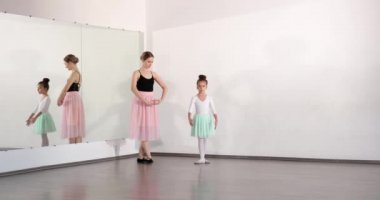 Dans stüdyosunda koçla küçük bir balerin eğitimi.