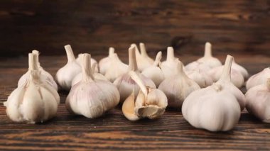 Tahta masaya taze sarımsak koyan kadın.