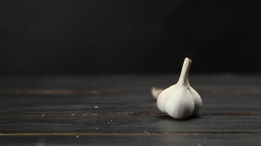 Koyu ahşap masaya düşen sarımsak karanfilleri