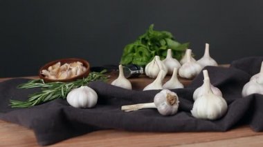 Tahta masada taze sarımsak ve bitkiler.