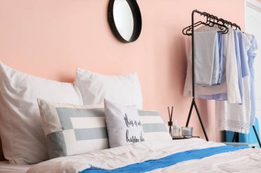 Elbise askısı olan şık bir yatak odası.