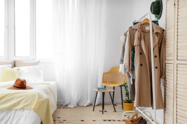 Elbise askısı olan şık bir yatak odası.