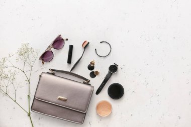 Hafif arkaplanda şık çanta, kozmetik ürünler ve aksesuarlar ile kompozisyon