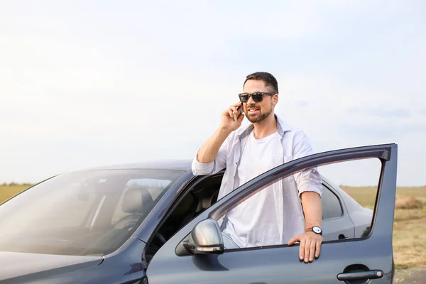Красивий Чоловік Розмовляє Мобільному Телефону Біля Своєї Сучасної Машини — стокове фото