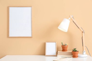 Renk duvarının yanında boş fotoğraf çerçeveleri olan şık bir iş yeri