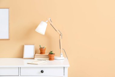 Renk duvarının yanında boş fotoğraf çerçeveleri olan şık bir iş yeri