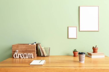 Renk duvarının yanında boş fotoğraf çerçeveleri olan şık bir iş yeri