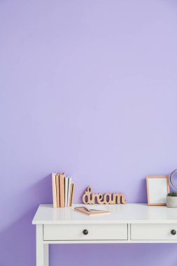 Renk duvarının yanında boş fotoğraf çerçevesi olan şık bir iş yeri