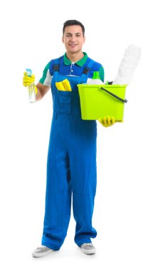 Beyaz arka planda temizlik malzemeleri olan genç bir erkek hademe.
