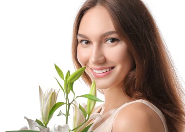 Beyaz arka planda taze zambakları olan güzel genç bir kadın.