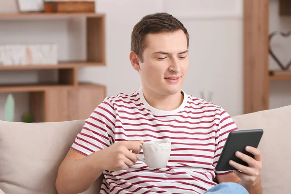 Young Man Reading Book Drinking Tea Home — Stock Photo, Image