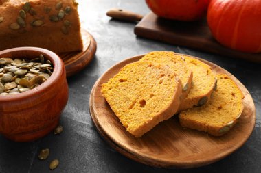 Koyu arkaplanda lezzetli balkabağı turtası olan tabak.