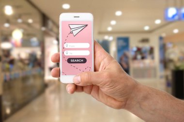 Cep telefonlu bir adam çevrimiçi uçuş biletlerini ayırtıyor.