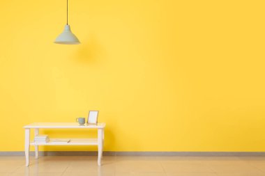 Renkli duvarın yanındaki masa çok şık.