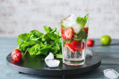 Masada bir bardak taze çilekli mojito.