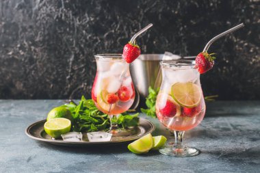 Koyu arkaplanda taze çilekli mojito bardakları.