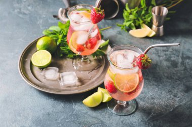 Koyu arkaplanda taze çilekli mojito bardakları.