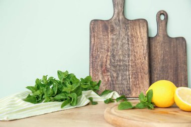 Mutfak masasında taze nane, limon ve ahşap tahta.