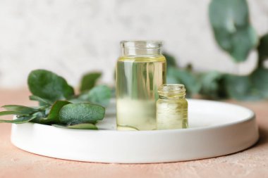 Masanın üzerinde okaliptüs şişeleri olan bir tepsi.