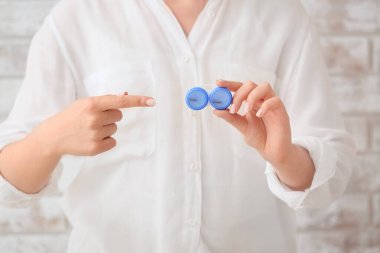 Konteynırı kontak lenslerle gösteren kadın, yakın plan