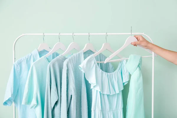 Vrouwelijke Hand Rek Met Kleding Buurt Van Kleur Muur — Stockfoto