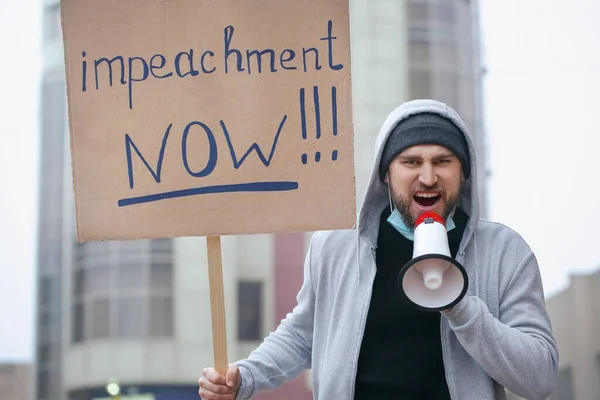 Protesting man outdoors. Impeachment concept