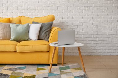 Rahat kanepesi ve dizüstü bilgisayarı olan şık bir oda.