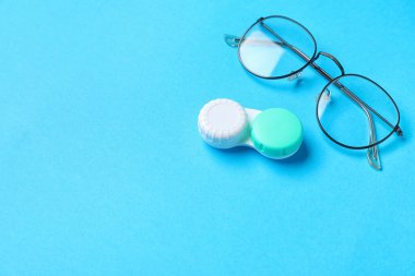 Renk arkaplanında kontak lens ve gözlüklü bir konteyner