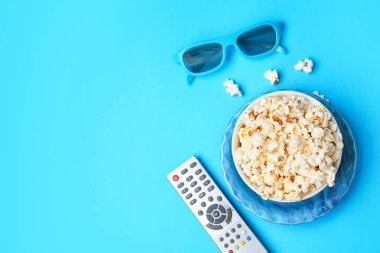 Lezzetli patlamış mısır, televizyon uzaktan kumandası ve arka planda 3 boyutlu gözlük.