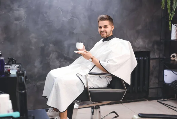 Przystojny Mężczyzna Filiżanką Kawy Salonie Fryzjerskim — Zdjęcie stockowe