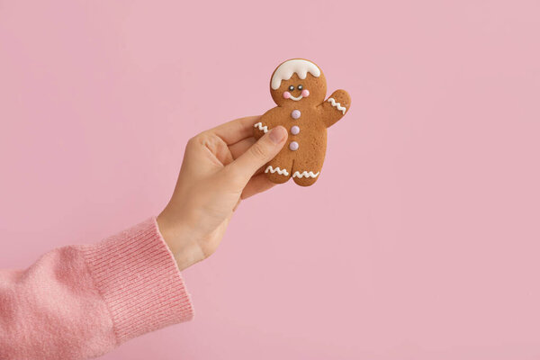 Женщина держит рождественское печенье на цветном фоне