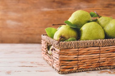 Masada taze olgun armutlarla dolu bir sepet.