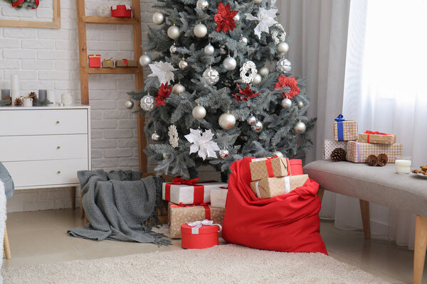 Interior of modern room with Santa bag, treats and Christmas tree