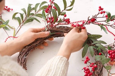 Masada güzel bir Noel çelengi yapan kadın.