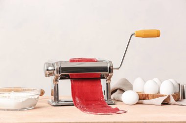 Mutfak masasında hamuru olan makarna makinesi.