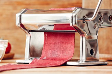 Mutfak masasında hamurlu makarna makinesi, yakın plan.