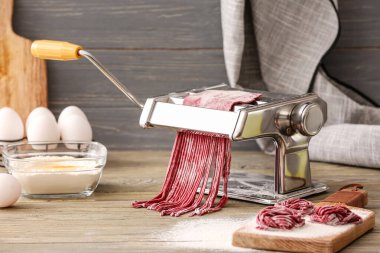 Mutfak masasında hamuru olan makarna makinesi.