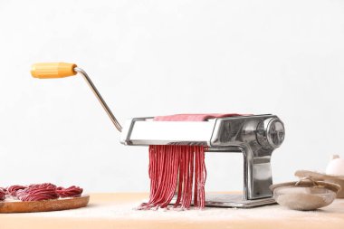 Mutfak masasında hamuru olan makarna makinesi.