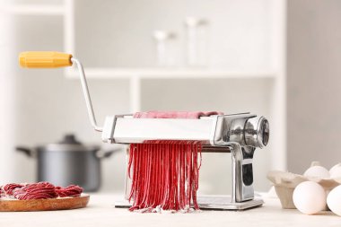 Mutfak masasında hamuru olan makarna makinesi.