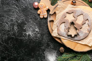 Siyah arka planda zencefilli kurabiye ve kesiciler için taze hamurlu Noel kompozisyonu