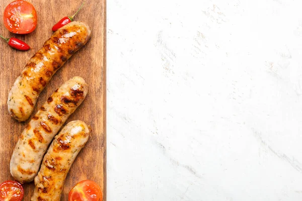 Holztafel Mit Leckeren Grillwürsten Und Gemüse Auf Hellem Hintergrund — Stockfoto