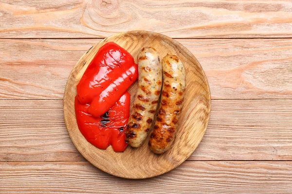 Holzteller Mit Leckeren Grillwürsten Und Gemüse Auf Holztisch — Stockfoto