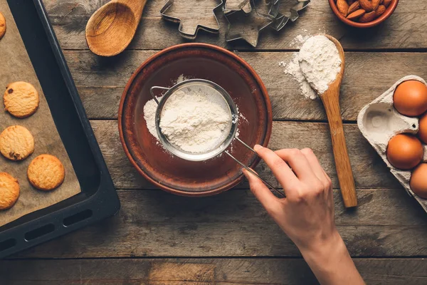 Woman preparing bakery on table, top view