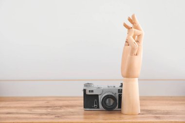 Odanın içindeki masada fotoğraf makinesi olan tahta el.