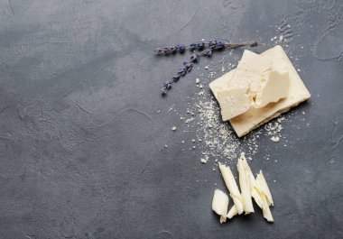 Koyu arkaplanda lavanta çiçekleri olan çikolata parçaları.