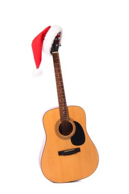 Beyaz arka planda Noel Baba şapkası olan gitar.