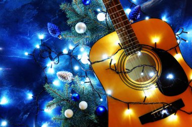 Noel ışıkları ve renk arkaplanı dekoru olan gitar